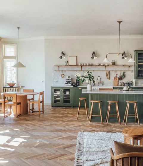 Spacious kitchen-dining area featuring green cabinetry, wooden accents, herringbone floors, and a cozy, natural aesthetic in an Airbnb in Kyritz, Germany [1080x1253]