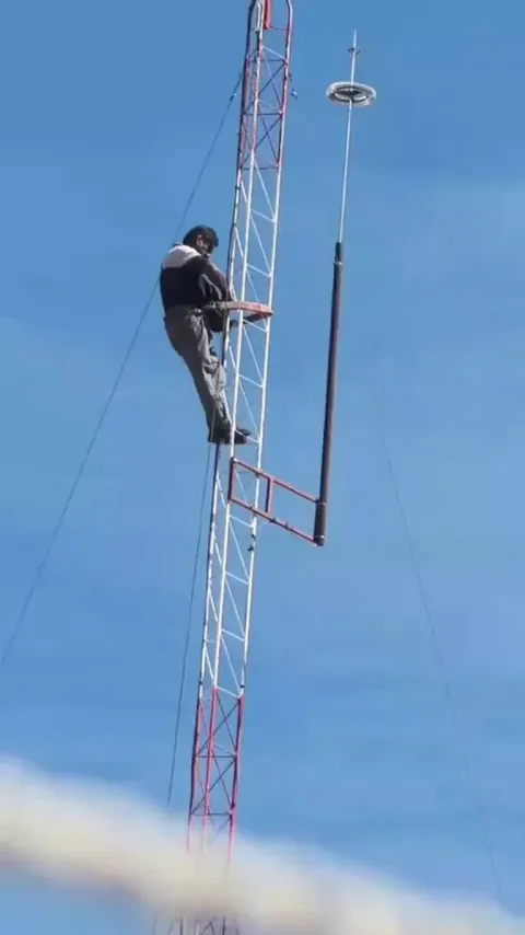 Man loses his adhesive tape while on top of an antenna