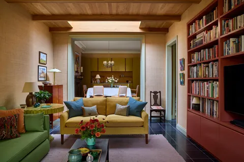 Sitting room with a skylight ceiling clad with oak beams and boardingin a renovated north London flat, UK [2627x1752]