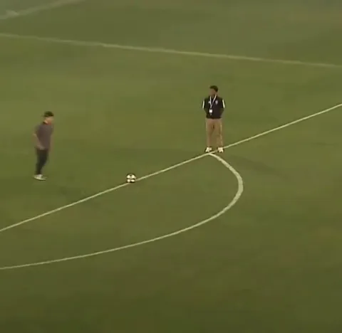 A kid kick the soccer ball exactly in the circle