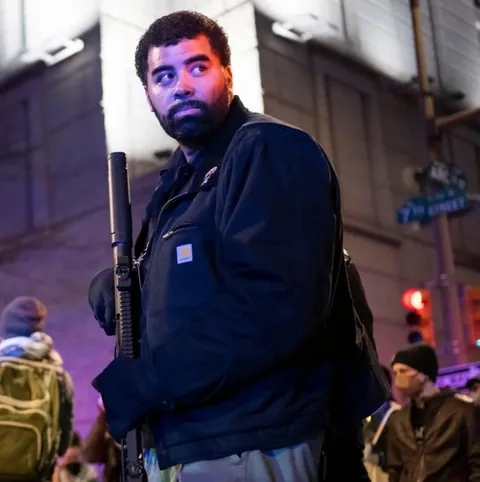 Armed members of the Black Panther Party walk through downtown and join protest [OC]