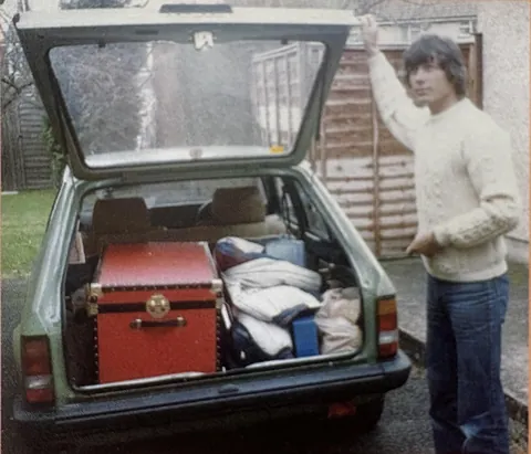 My Dad Packing up his life to start his move to America from Scotland 1980 (he still has that red trunk and that sweater)