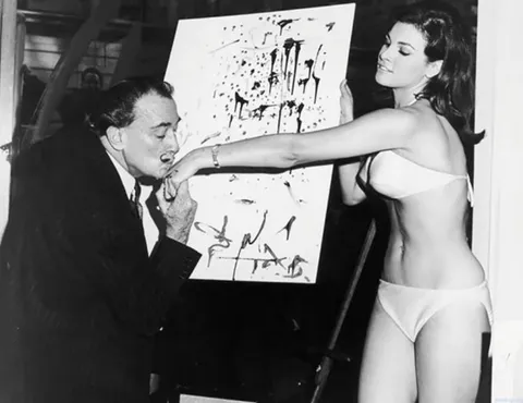 Salvador Dali kisses Raquel Welch's hand after completing his famous portrait, 1965.