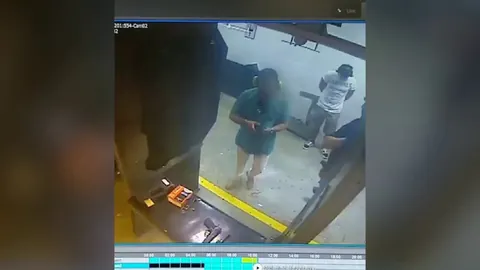 A man points a loaded gun at his friend's head