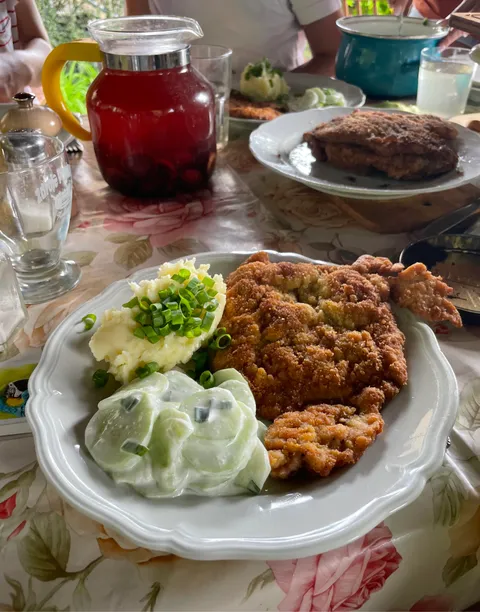 Sunday lunch in Grandma's garden in Poland. Pork chop, mashed potatoes, cucumbers in sour cream and plum drink.