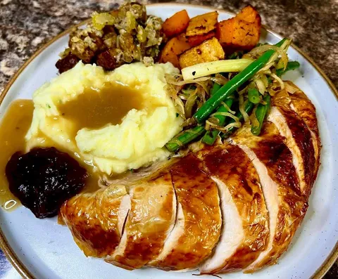 Thanksgiving dinner made by a Brit. . . Crispy skinned turkey, creamy mash, crouton, sausage meat and sage stuffing, roasted butternut squash with a pinch of paprika, warmed spicy green bean, green onion and cabbage salad and cranberry sauce. All made from scratch.
