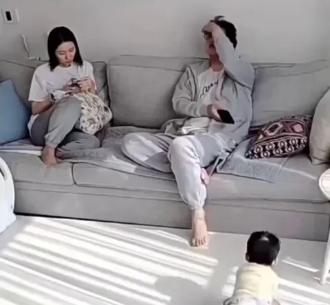 Parents watching their kid take his first steps