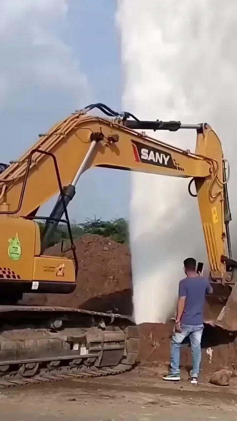 Excavator attempts to block a powerful underground water burst