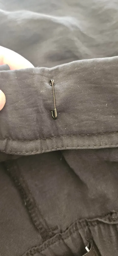 Use safety pins to quickly and cheaply reduce the waist size of pants with a hook and bar closure