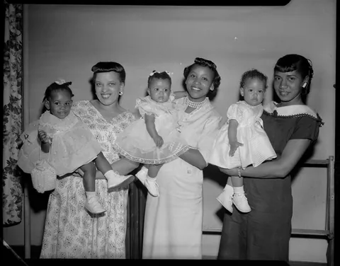 Mothers showing off their little baby girls as they compete in a little contest. May 1957