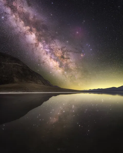 The Milky Way reflecting perfectly in a salt flat at night. Photograph taken by Abhijit Patil.