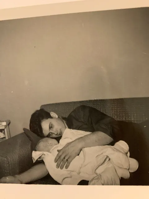 1957, My grandpa (18) holding my mom on his parent's couch in the Cleveland suburbs. He was a "tough" greaser but still has a big soft spot to this day.