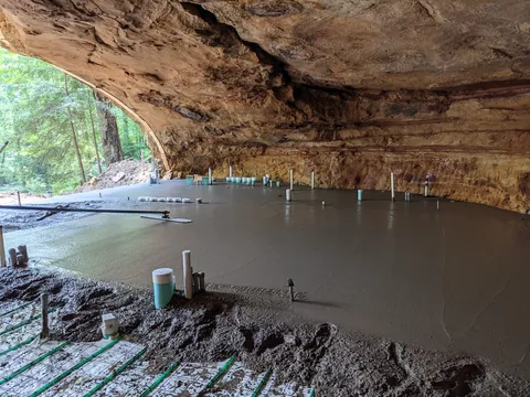 Is building under a huge rock like this safe? My first thought when I say this was earthquakes.