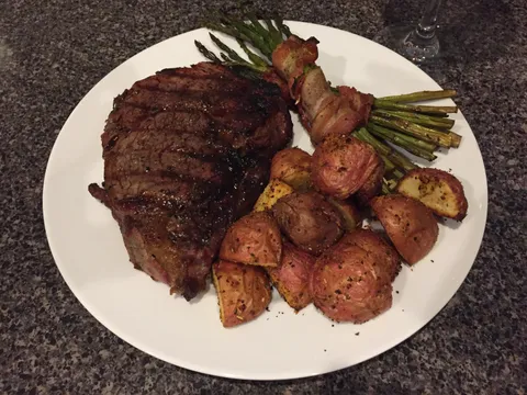 Buddy gave me a free grill, so I made him this; 16 oz Ribeye, Bacon Wrapped Grilled Asparagus, and Herb Roasted Red Potatoes [1334x750]