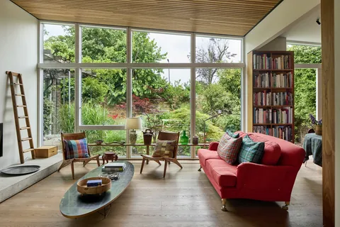 Living room with floor-to-ceiling windows facing the garden in a 1960s modernist residence, Dulwich, south east London, UK [1600x1067]