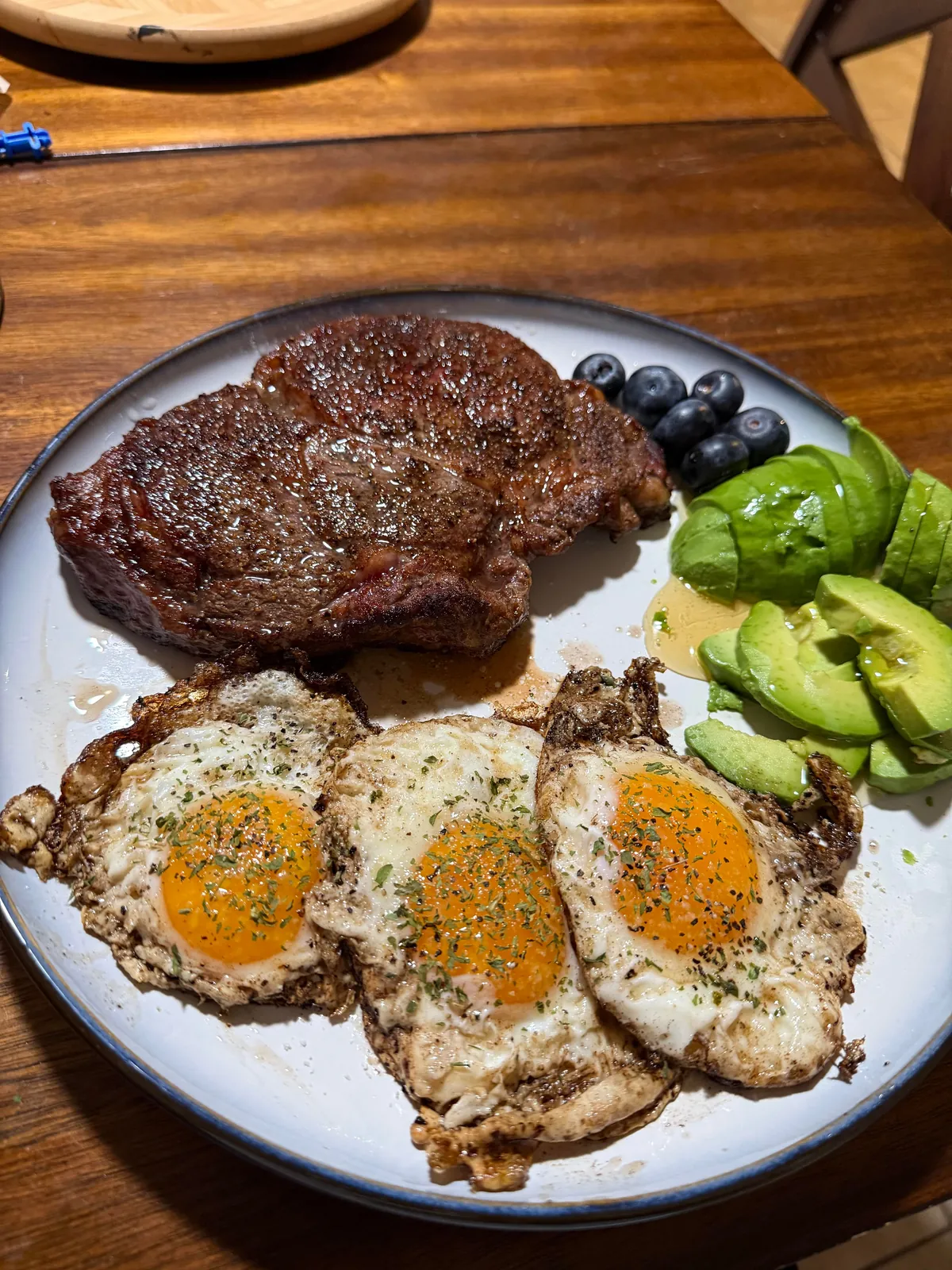 [Homemade] Ribeye with eggs, avocado, and blueberries.