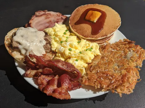 My Grand Slam style breakfast. Buttermilk pancakes, eggs, hash brown, bacon, ham, biscuit, sausage links, and gravy