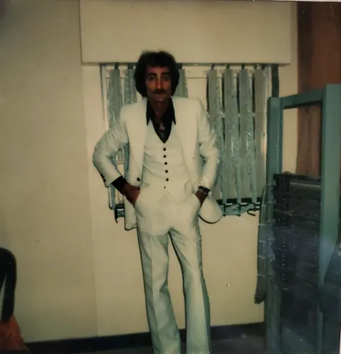 My dad posing in front of a telephone system main frame he built. (1977)