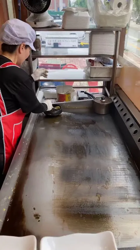The way this street vendor smooths out and rolls an egg omelette
