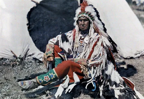 Autochrome shot of a Native American which shows details and tones of his traditional clothes, late 1910s.
