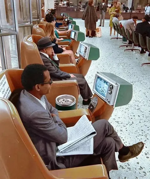 People watching coin operated tvs in a bus station in LA – 1969