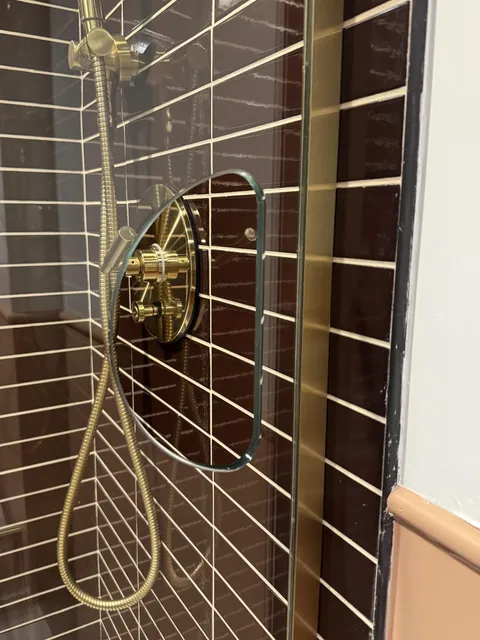 This hotel shower has a hole so you can turn the water on without getting wet (door opens from opposite end)