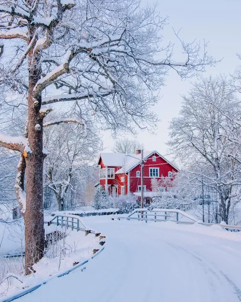 Bright red farmhouse in the snowy landscape of Årjäng, Årjäng Municipality, Värmland County, Sweden.