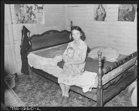 "Mrs. Walter Rose, wife of miner, and her baby. She lives in three room, extremely dirty house. The baby probably has rickets and has never had any other food than powdered milk although he is ten months old." Welch, McDowell County, West Virginia, 1946