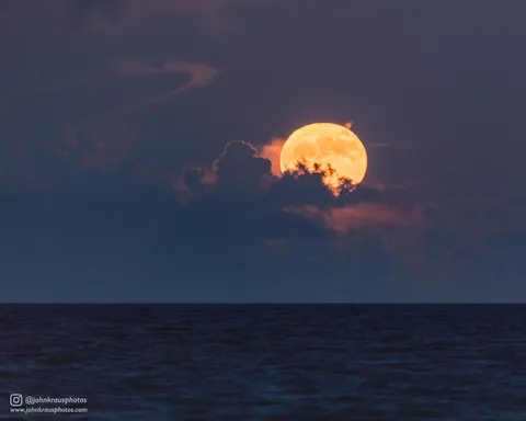 I photographed the full moon rising over the ocean through some clouds and atmospheric distortion, which rendered the moon a beautiful yellow-gold hue.