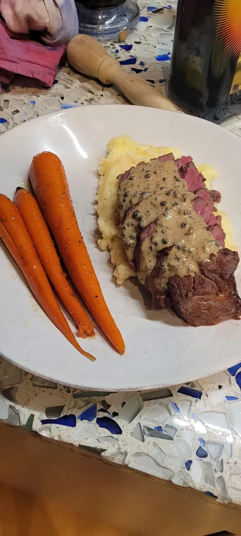 Steak au poivre, mashed potatoes and caramelized carrots