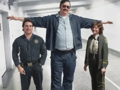 Ed Kemper striking a T-pose with the officers who arrested him in 1973. He was 6'10 !