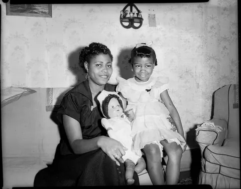Little girl gives a bright smile with her doll (could be a gift from her mother in the second photo, Circa 1950s Kodak safety film.