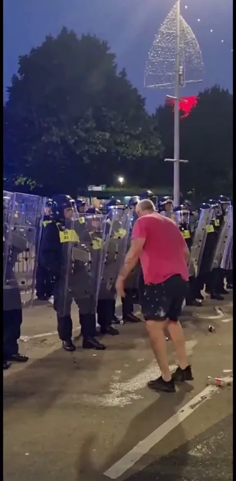 Rioter gets sat down by police