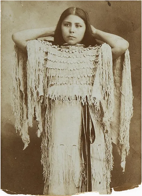 Native American woman wearing a valuable Elk tooth dress, possibly 1890s