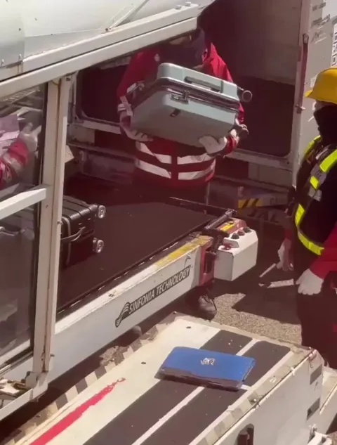 Airport staff gently handling luggage