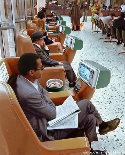 People watch coin-operated televisions while waiting in the Los Angeles Greyhound Bus terminal in 1969.