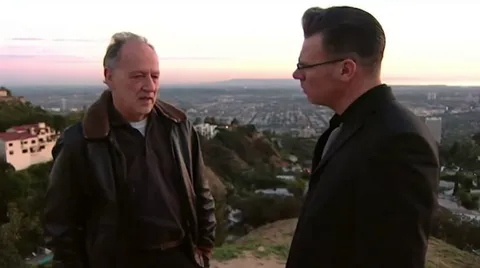 Werner Herzog getting shot with an air rifle and barley reacts to it.