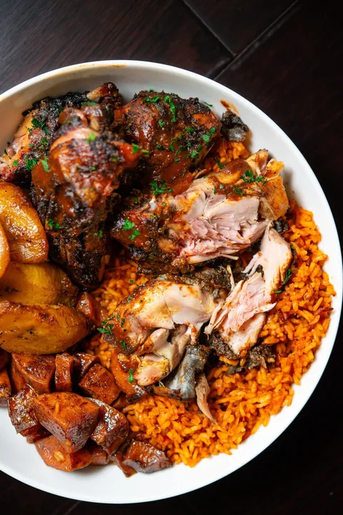 [homemade] smoked jerk chicken, jollof rice, collard greens, plantains and candied yams. 