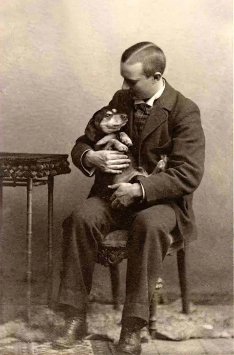 Gentleman pose for photos with their beloved pups, circa 1880-1900