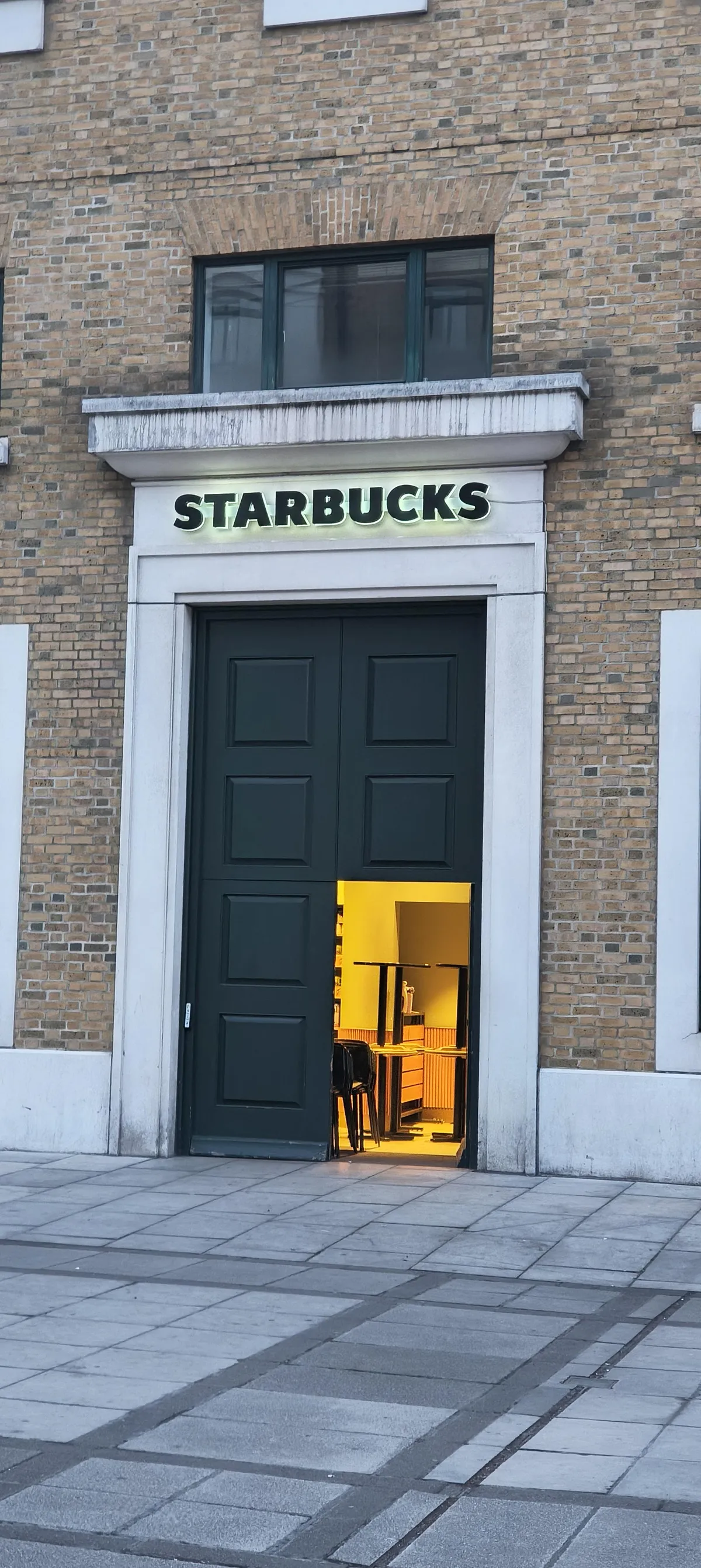This normal sized door in a big door to a Starbucks