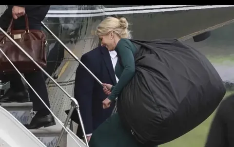 PsBattle: Natalie Harp carrying a bag onto an airplane