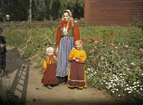 Swedish woman poses with her children close to a garden. One of the kids moved her head a little and came out blurry, Sweden, 1910. Autochrome lumiere.
