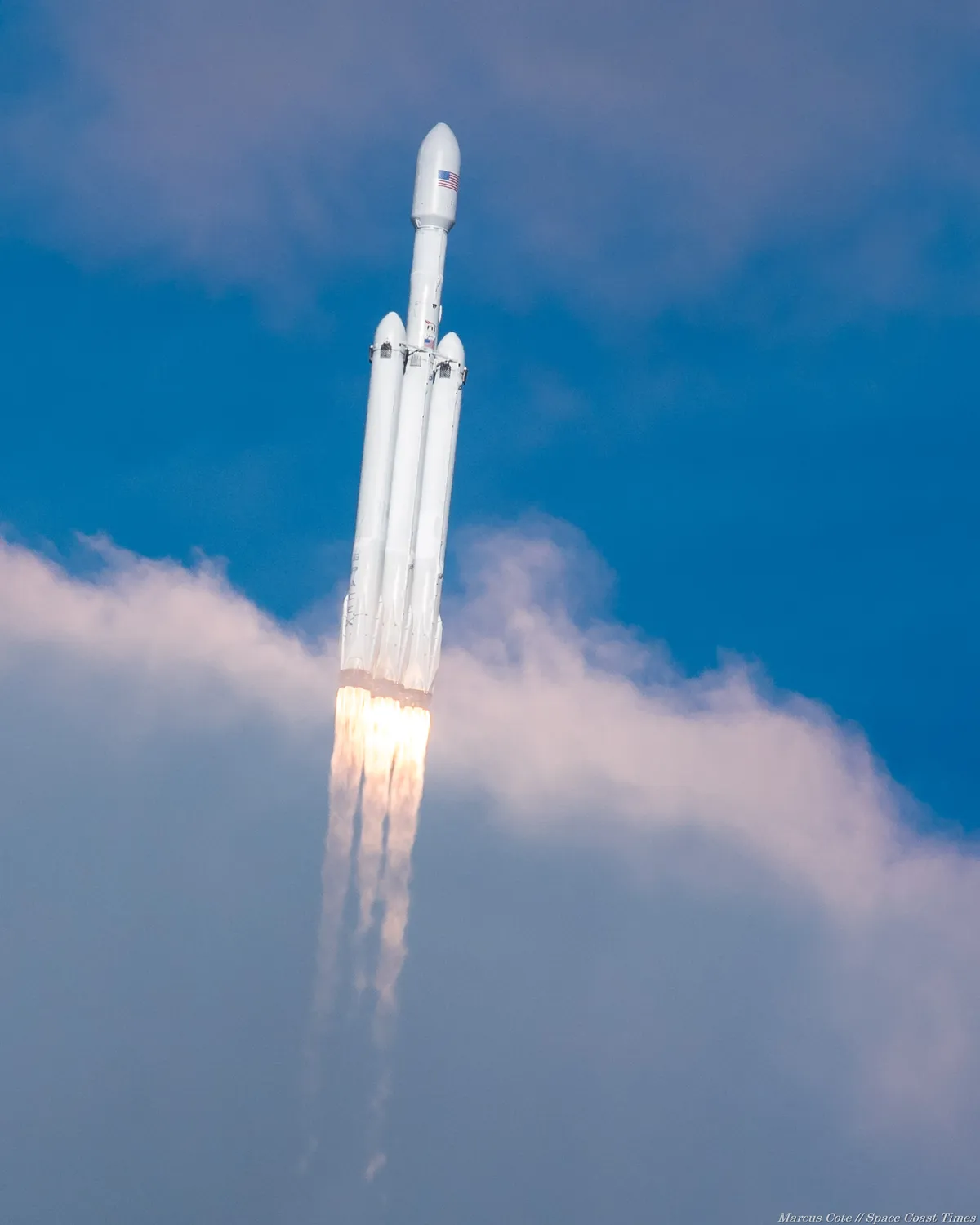 I photographed Falcon Heavy passing through clouds that temporarily revealed more detail of its three 9-engine cores.