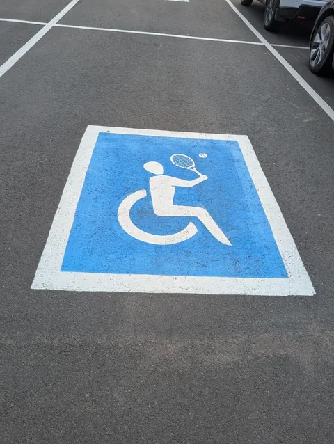 Spotted creative handicap parking signs depicting different parasports outside a sporting goods store