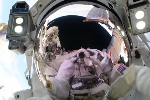 NASA Astronaut Anne McClain takes a "space-selfie" during a spacewalk, with NASA astronaut Nichole Ayers also reflected in her visor.