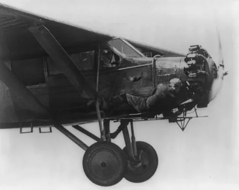 One of the Hunter brothers checks the engine of their plane while in flight. This was during their record 23 day non stop flight: 11 of June 1930 to 4 of July 1930. Source in comment