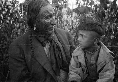 An elderly Northern Cheyenne man with a young boy. (c. 1927)