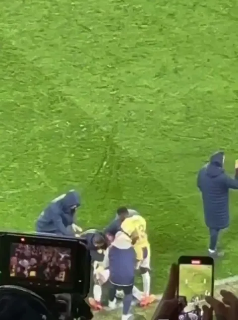 Jose Mourinho grabs the attention of his assistant manager to discuss tactics on the bench urgently.