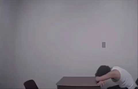Man escapes the interrogation room by kicking a whole in the wall