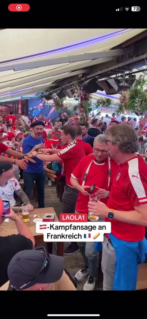 Austrian fans snapping baguettes in front of French fans